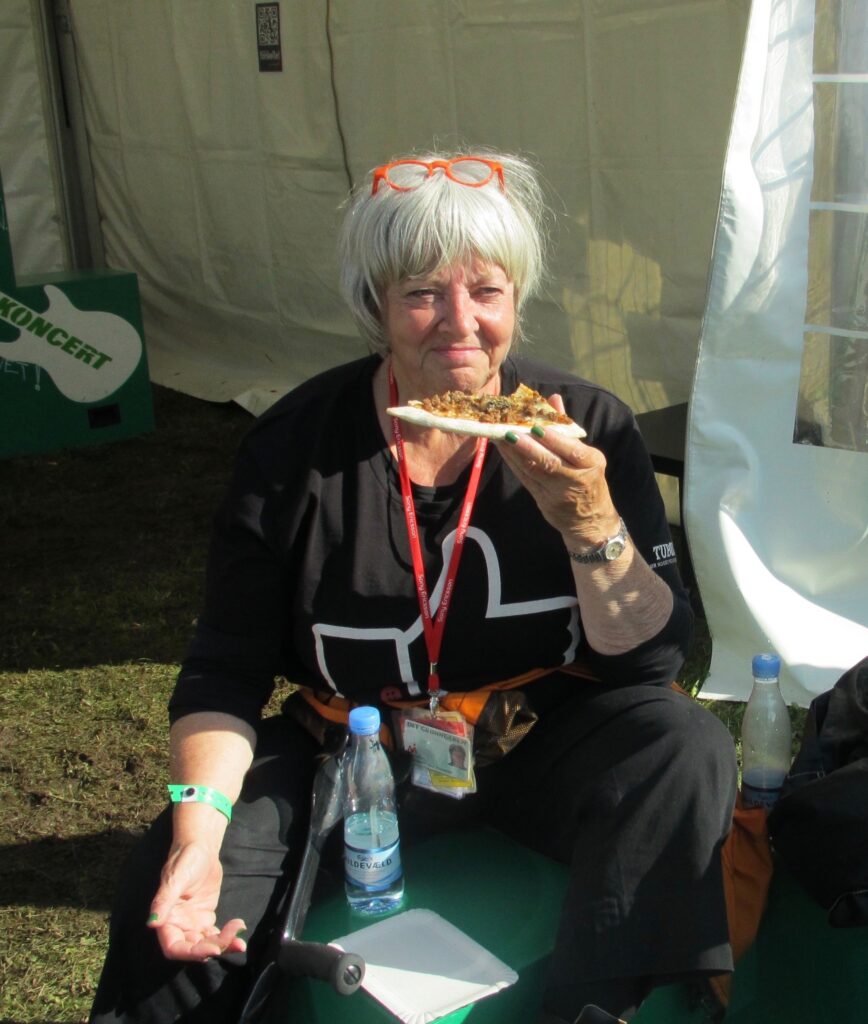 Annemarie Mikkelsen som frivillig på Grøn i en pause. spiser pizza